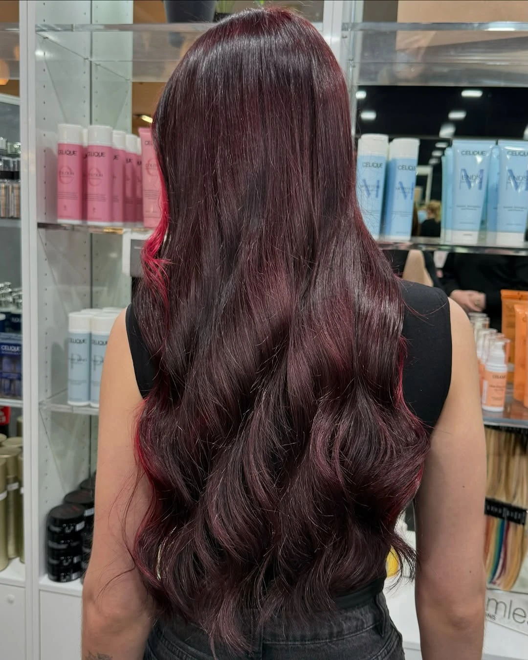 Long dark burgundy hair with deep red tones waved from mid-length down