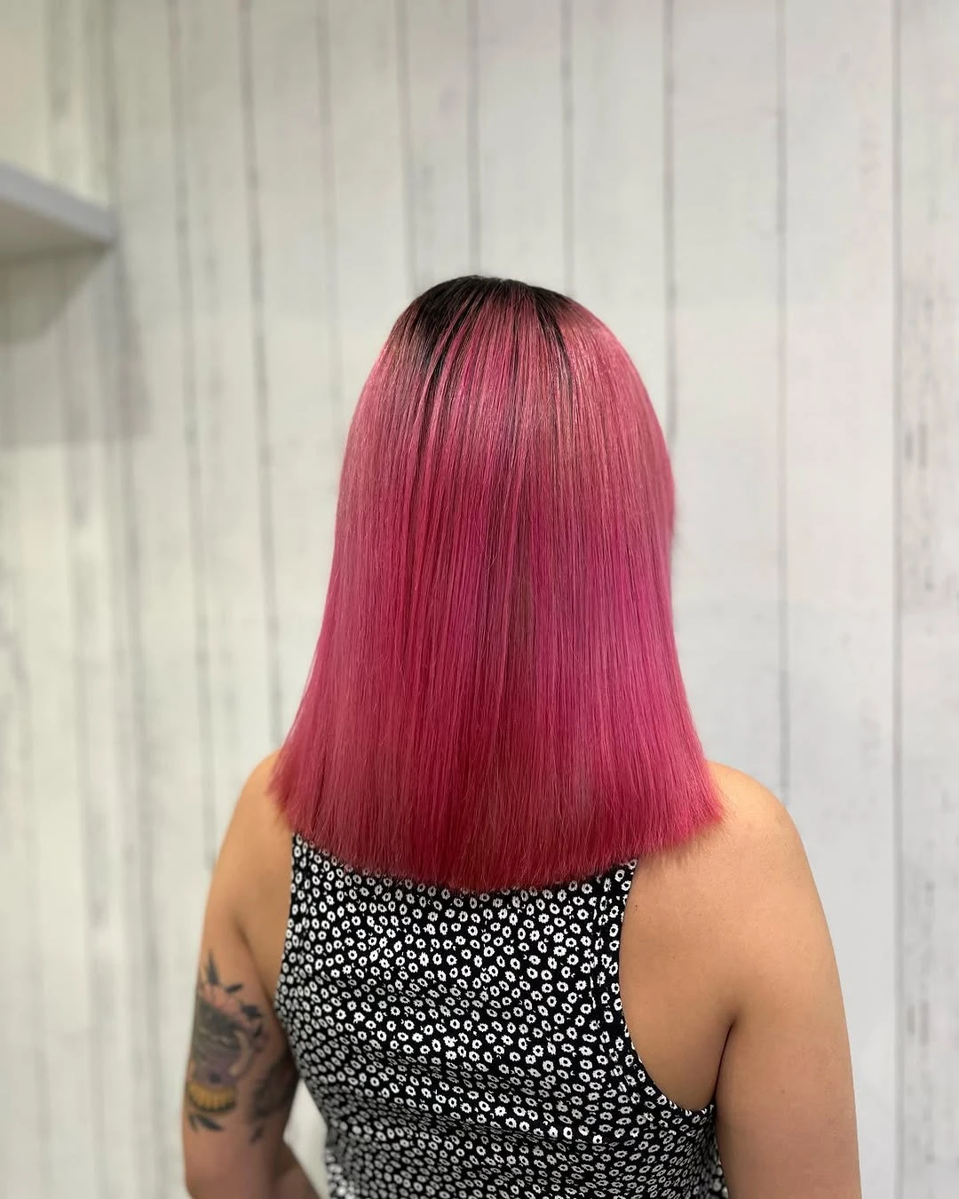 Blunt bob cut to the jaw and coloured bright pink with a deliberate dark root