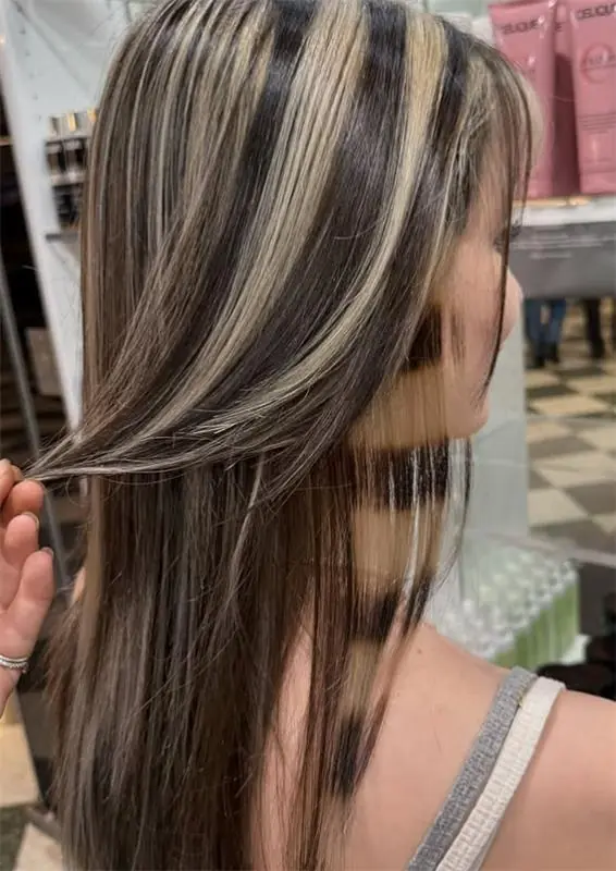 Long straight brunette hair with cool blonde highlights and a bright face-framing panel