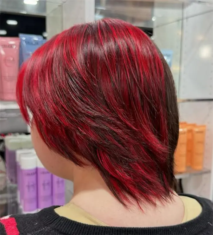 Short layered bob coloured glossy deep red with brighter red ribbons