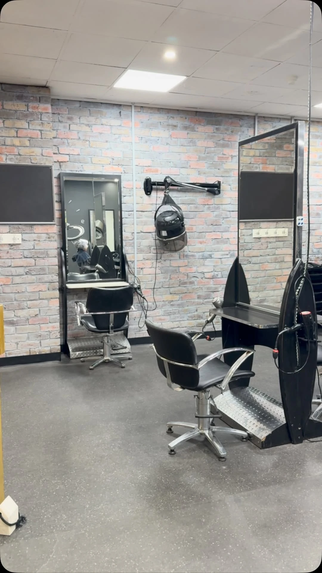 The Bleach Please salon floor in Charlestown — styling chair, mirror and brick feature wall