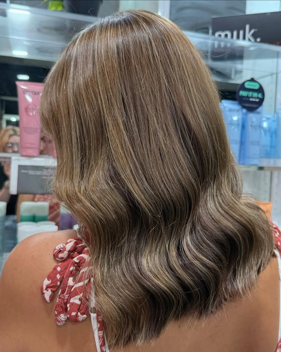 Mid-length bronde balayage blow-dried into soft waves through the lengths